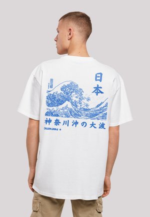 Witte katoenen t-shirt met een blauwe golfafbeelding en Japanse tekst op de achterkant. Korte mouwen en een relaxed fit met een ronde halslijn.
