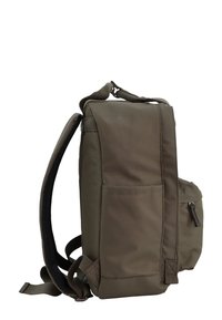 Zaino verde oliva con forma rettangolare, realizzato in tessuto resistente, presenta tasche frontali e laterali, spallacci regolabili e dettagli testurizzati.