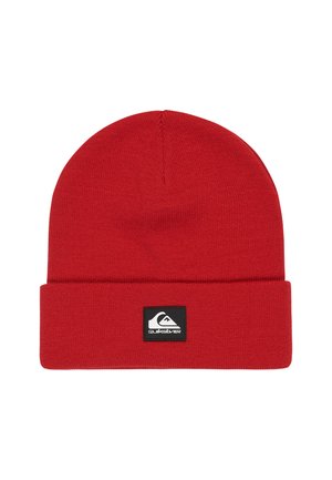 Un bonnet en tricot rouge avec un revers replié et une patch rectangulaire noire arborant le logo Quiksilver blanc à l'avant.