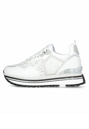 Sneaker sportive bianche con tomaia perforata, dettagli grigi, una suola spessa nera e bianca, e un particolare metallico sul tallone.