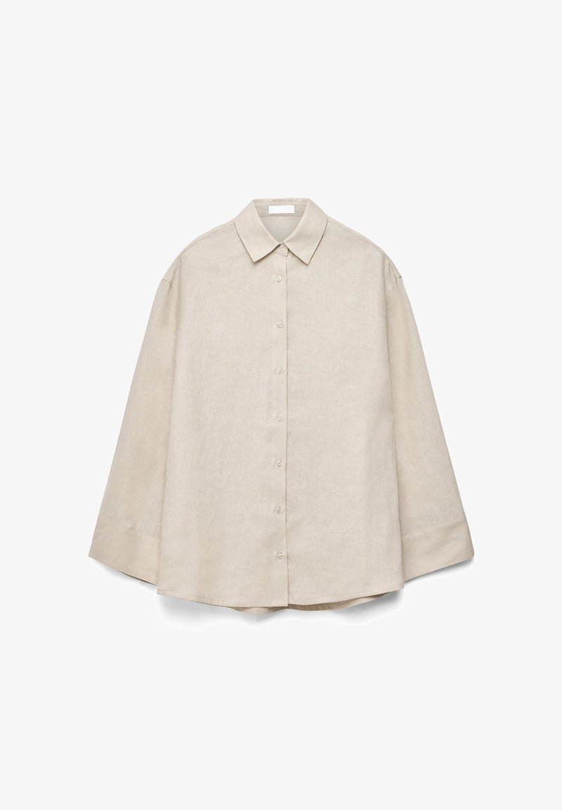 Šviesiai ruda ilgas rankovėmis palaidinė su sagomis, pasižyminti smaigaliu apykakle, matomomis sagomis priekyje ir laisvu siluetu, išdėstyta ant balto fono.