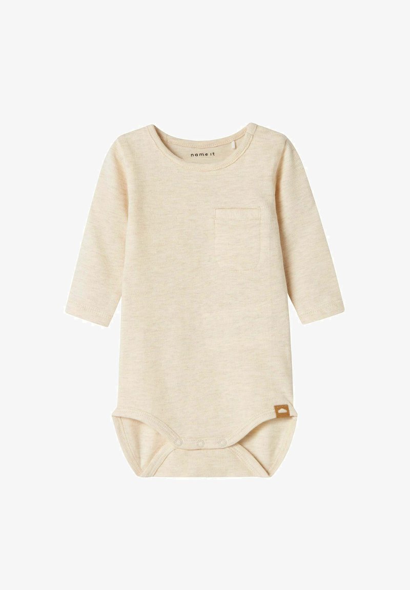 Body pour bébé à manches longues en beige clair, texture côtelée, avec une poche poitrine et des boutons-pression au bas. Accents en étiquette marron.