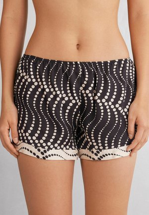 Zwarte shorts met een patroon van witte golvende lijnen en stippen, voorzien van een elastische tailleband en een gladde stofafwerking.