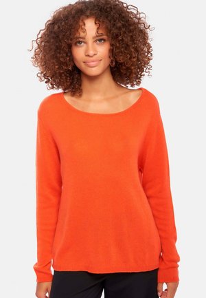 Pull en tricot orange avec un grand col rond et des manches longues. Texture douce avec une coupe décontractée, descendant en dessous des hanches.