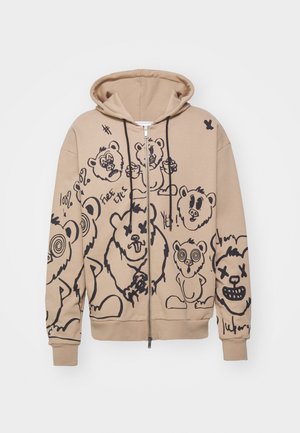 Beige vetoketjullinen huppari, jossa mustia piirroskarhujen kasvoja ja graffitityylisiä tekstejä edessä ja hihoissa, hupussa mustat nyörit.