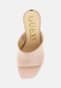 Sandal in ecopelle rosa con punta quadrata, texture liscia e logo metallico "GUESS" sulla soletta.