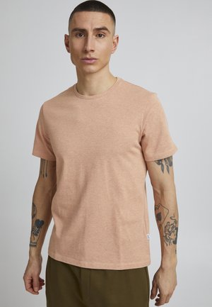 Light peach short-sleeve t-shirt in a soft, breathable fabric with a classic round neckline and discreet logo detail on the chest.