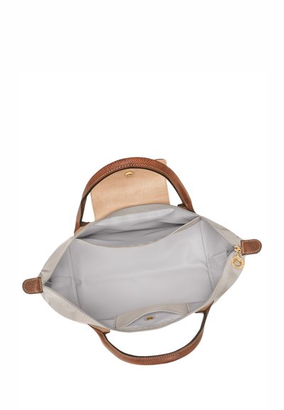 Graue Lederhandtasche mit braunen, strukturierten Griffen, geräumigem Innenraum und einem goldenen Metallverschluss. Das Innenfutter ist glatt und hellgrau.