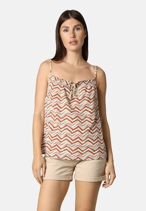 Lichte, mouwloze top met een chevronpatroon in roest en roomkleur. Kenmerkt zich door een geplooide halslijn met een strik. Gecombineerd met beigekleurige shorts.