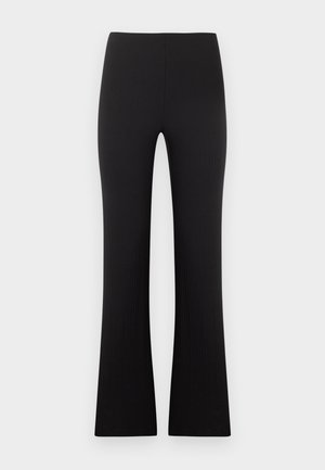 Svarte ribbestrikkede bukser med høy midje og en lett vidde nederst, lagt flatt på en lys grå bakgrunn.