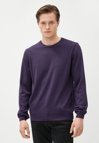 Lila Langarmpullover aus weichem Strickmaterial. Verfügt über einen runden Ausschnitt sowie gerippte Bündchen und Saum, mit einem klassischen, taillierten Design.