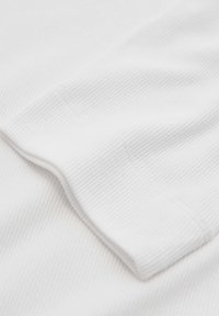 Tessuto bianco a righe con una texture liscia, caratterizzato da un orlo delle maniche piegato e un sottile dettaglio di cucitura. Design minimalista.