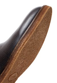 Bruine leren schoen met een gestructureerd oppervlak, met een rubberen zool in een natuurlijke bruine afwerking en een gladde, ronde neuskapsel.