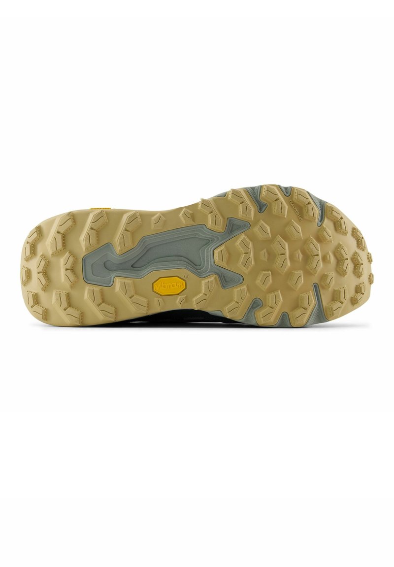 Semelle de chaussure avec des crampons multidirectionnels beige et gris, conçus pour la traction et la durabilité sur un terrain accidenté.