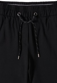 Schwarze Jogginghosen mit elastischem Bund, verstellbarem Kordelzug in Schwarz und Weiß, ausgestattet mit metallischen Spitzen in Silberton und glatter Stofftextur.