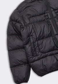 Giacca a vento nera con una texture liscia e lucida, dotata di una zipper frontale, due tasche e un design a trapunta per l'isolamento.