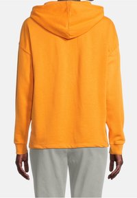 Oranžová mikina s kapucí ve volném střihu, s dlouhými rukávy a stahovací kapucí. Měkká látka s žebrovanými manžetami a lemem pro pohodlí.
