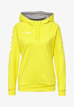 Jasnożółta bluza z kapturem z szarym wewnętrznym podszyciem kaptura, sznurkami, białym logo hummel na piersi i białymi pasami w kształcie szewronów na rękawach.