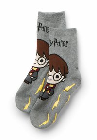 Graue Socken mit einem Cartoon-Charakter, der braunes Haar und eine Brille trägt, gekleidet in einem schwarzen und roten Outfit, das mit gelben Blitzen akzentuiert ist.
