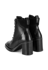 Melnas ādas potītes zābakus ar strukturētām blokveida papēžiem, sānu rāvējslēdzējiem un vilkšanas cilpiņām; gludi un matēti pretstatā materiāliem.