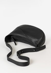 Borsa a tracolla in pelle nera con design curvo, chiusura zip e tracolla regolabile. Texture liscia e dettagli delle cuciture sottili.