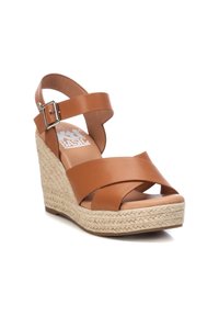 Sandali wedge in pelle marrone con fasce incrociate, fibbia regolabile alla caviglia e piattaforma avvolta in juta. Texture liscia e design minimalista.