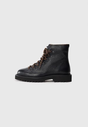 Black leather hiking boot with a textured finish. Features brown laces, metal eyelets, and a rugged sole for traction. Ankle height silhouette.