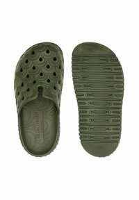 Groene rubberen klompen met een gegolfd ontwerp en perforaties voor ventilatie. Textuur, non-slip zool met het merkteken op de binnenzool.