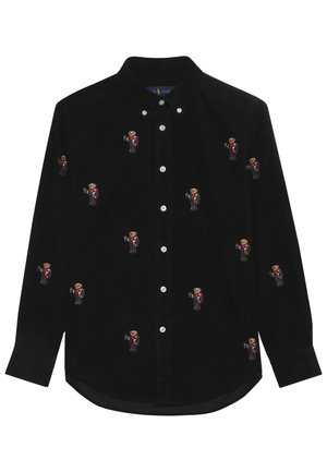 Chemise noire à manches longues, boutonnée et munie d’un col, ornée de petits ours en peluche brodés portant des tenues rouges.