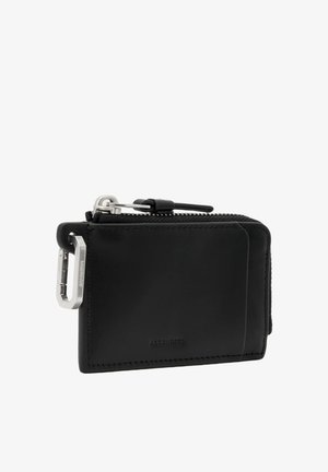 Portefeuille en cuir noir avec fermeture éclair, clip mousqueton en métal sur le côté et marquage embossé minimaliste.