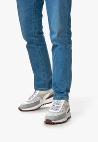Sneakers in gray, white, and light beige mesh with rubber soles. Features round laces, a padded tongue, and a slightly curved design.