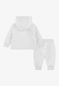 Γκρι ανοιχτό φούτερ με εφαρμοστή κουκούλα, ριμπ μανσέτες και αντίστοιχο καπιτονέ παντελόνι φόρμας με ελαστική μέση και μανσέτες, κατασκευασμένα από απαλό, υφή υφάσματος.