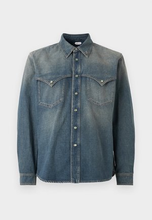 Slidt blå denimskjorte med trykknapper, spids krave, to brystlommer med klapper og lange ærmer.