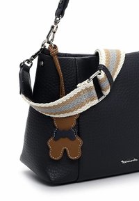Czarna torebka ze skóry o fakturze, wyposażona w odpinany paski w beżowo-szaro-brązowe paski. Charakterystyczny breloczek w kształcie misia wykonany z brązowej skóry.
