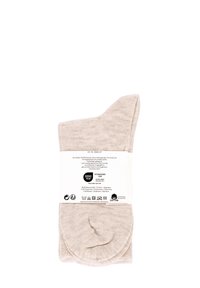 Chaussettes en coton beige avec une texture douce, présentant une couture de orteil plate et une étiquette à l'arrière indiquant le matériau et les instructions d'entretien.
