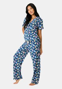 Tvådelat pyjamasset; kortärmad topp och långa byxor. Marinblå med färgglada katt-siluetter; lätt och andningsbart tyg, byxor med dragsko.