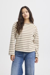 Brown and cream striped long-sleeve top with a round neckline, relaxed fit, and soft texture, paired with blue wide-leg jeans.