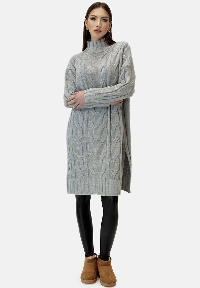 Ljusgrå kabelstickad klänning med hög krage, sidosprund och ribbad fåll. Matchad med svarta leggings och bruna ankelstövlar.