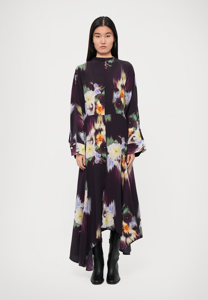 Long, flowing dress in dark purple with a floral pattern in shades of yellow, green, and orange. Features a high neckline and long sleeves.
