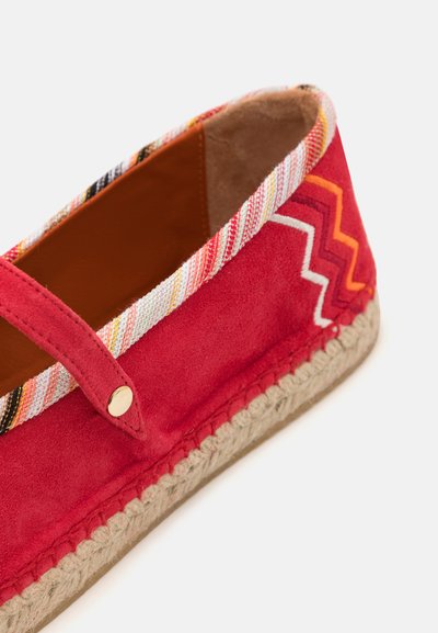 Espadrilhe em camurça vermelha com acabamento de têxtil multicolorido trançado, apresentando um padrão decorativo em zig-zag e uma sola envolvida em juta. Detalhe em dourado.