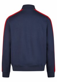 Marineblaues Zip-Jackett mit roten und weißen Seitenstreifen, geripptem Kragen und Bündchen, aus einem weichen, strukturierten Stoff hergestellt.