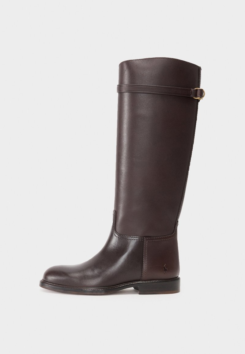 Brązowy skórzany kozak do kolan o gładkim wykończeniu, okrągłym nosku i ozdobnym pasku z złotymi elementami u góry. Płaska podeszwa.