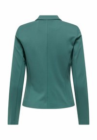 Blazer vert foncé à manches longues et col, avec une rangée de coutures verticales dans le dos pour plus de structure.