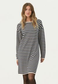 Abito a maglia a righe in blu navy e crema, con maniche lunghe, scollo ampio e vestibilità morbida che arriva sopra il ginocchio.