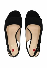 Zwarte suède sandalen met open teen, brede voorband, enkelband met een gesp en een beige binnenzool met een reliëf logo.