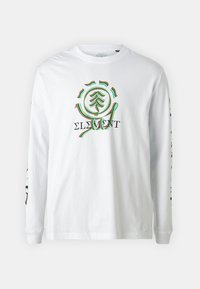 T-shirt bianco a maniche lunghe in cotone con un design di un albero colorato sul davanti e grafiche testuali nere lungo le maniche.