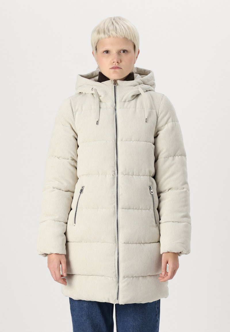 Veste matelassée en corduroy beige clair avec capuche, fermeture éclair à l'avant et deux poches zippées sur les côtés. Présente un motif matelassé horizontal et des manches larges.