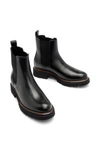 Czarne skórzane botki za kostkę z elastycznymi panelami bocznymi, teksturowanym wykończeniem i gumowymi podeszwami, z brązowym przeszyciem wzdłuż krawędzi podeszwy.