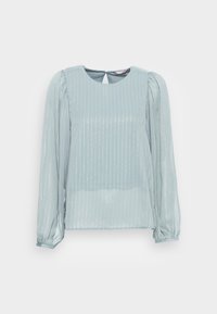 Blusa azzurra chiara con maniche lunghe e a sbuffo, caratterizzata da strisce verticali argentate e un dettaglio a chiave sulla schiena. Realizzata in un materiale trasparente.