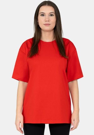 Red cotton t-shirt with short sleeves, round neckline, and a loose fit. Smooth texture, simple design, and no visible patterns or accents.